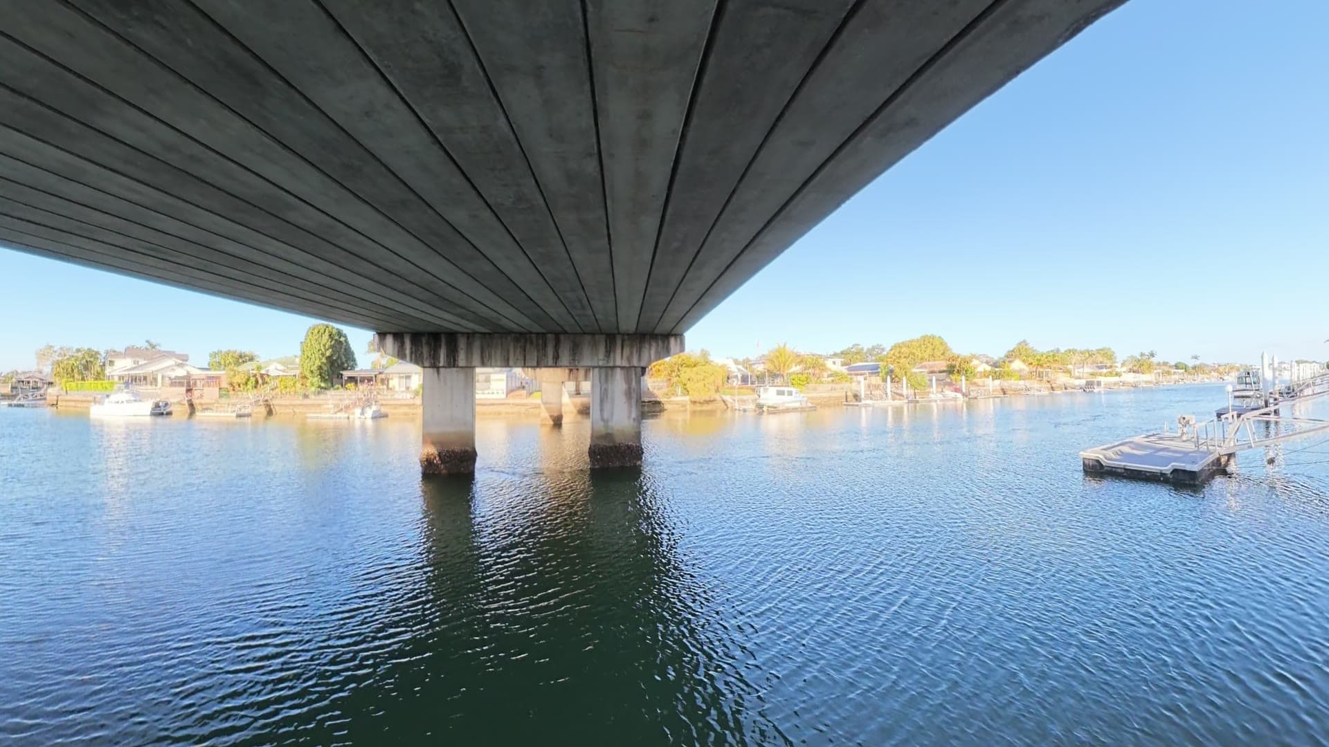 A 360 view beneath a bridge over water.