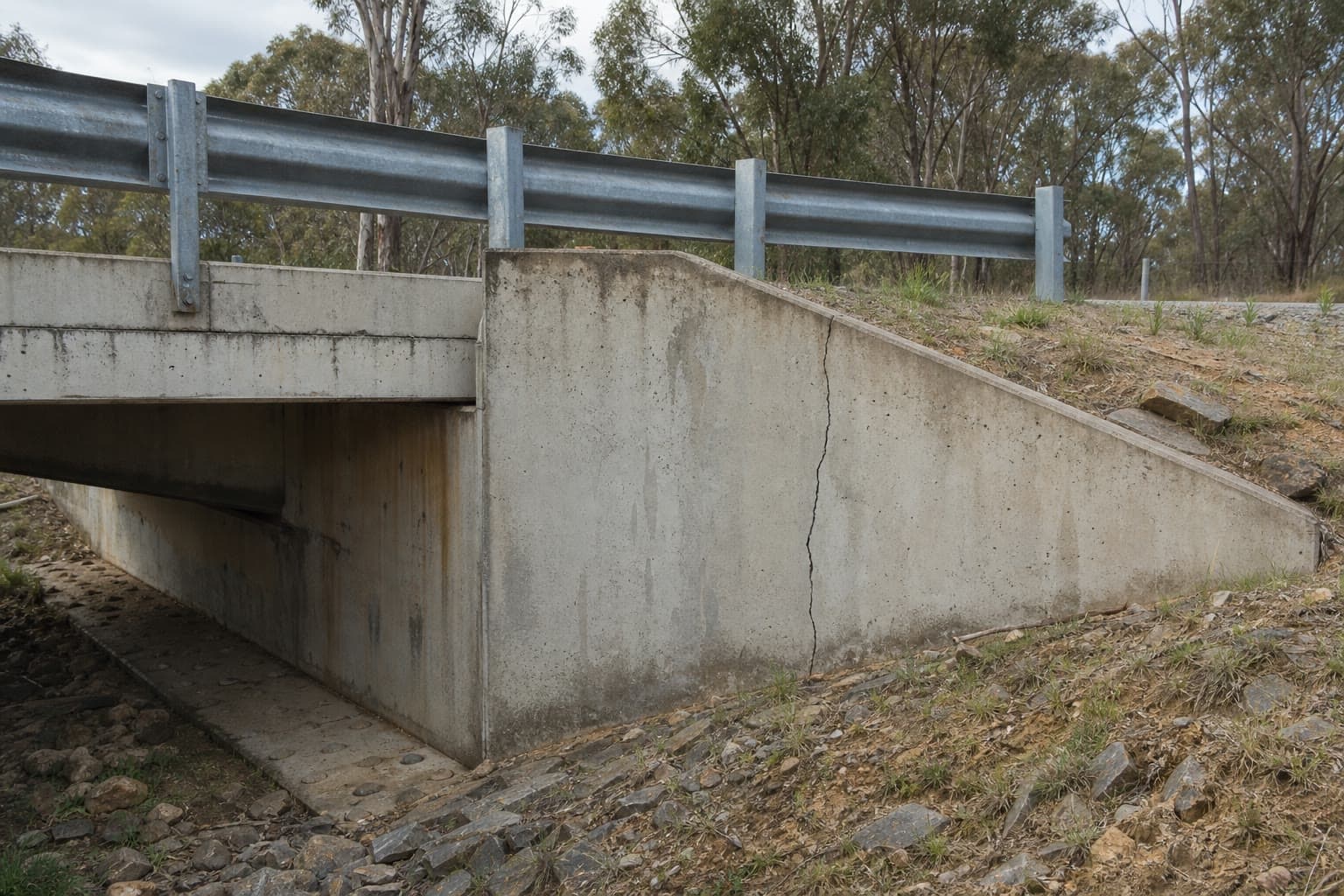 Concrete bridge abutment with a visible vertical crack.